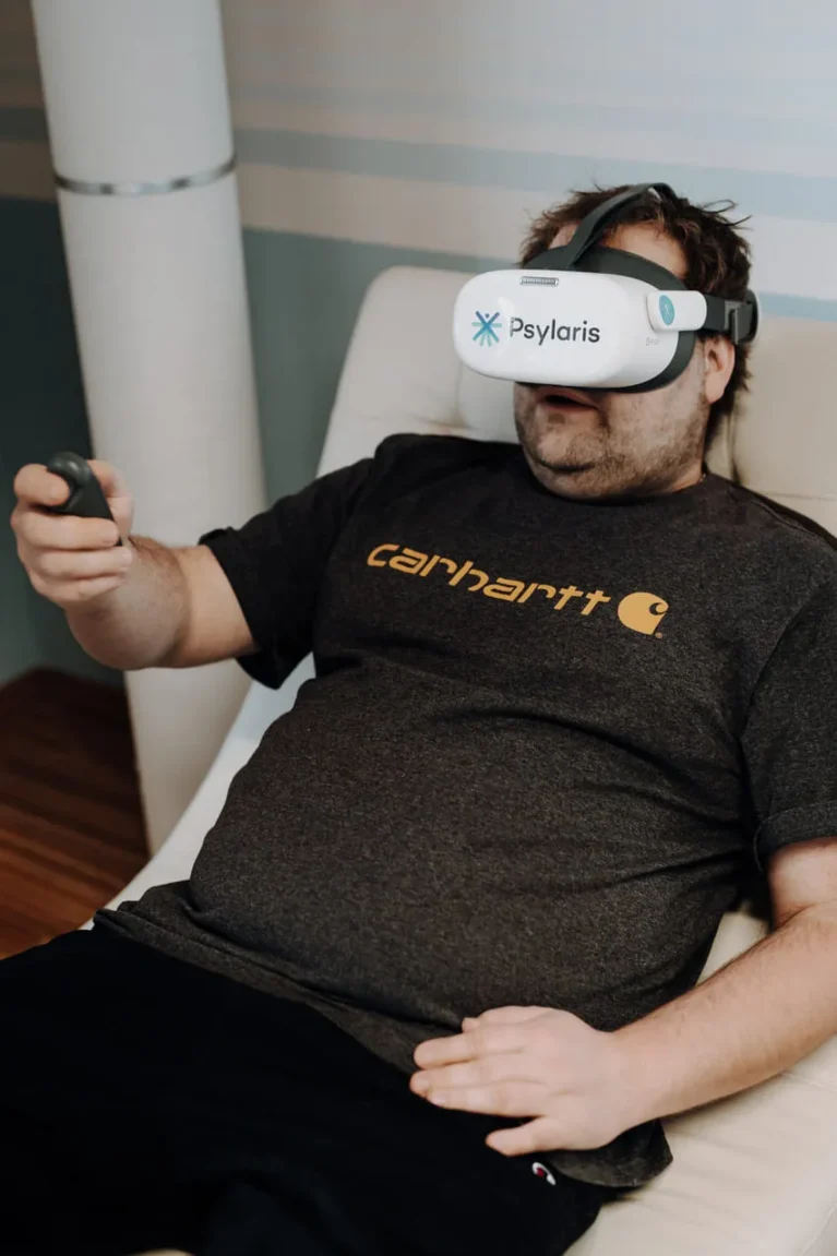 Person entspannt mit VR-Brille und Controller auf einem Sessel. Anwendung in der Psychotherapie möglich.